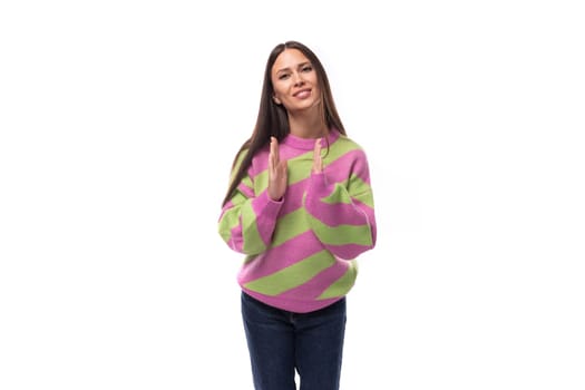 portrait of a well-groomed 35 year old feminine model woman dressed in a pink stylish pullover pointing her hand forward at the camera.