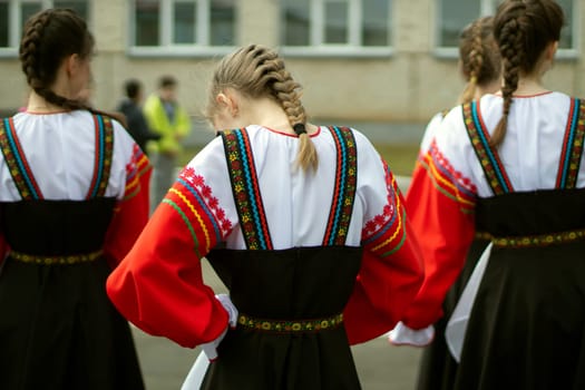 Girl in Russia in folk dress. Preparation for dance. Children perform on street with theatrical number. Folk style of clothing.