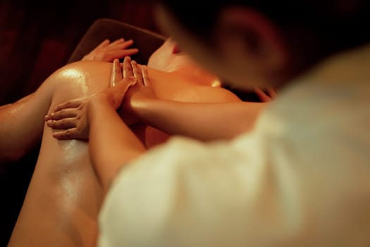 Caucasian man customer enjoying relaxing anti-stress spa massage and pampering with beauty skin recreation leisure in warm candle lighting ambient salon spa at luxury resort or hotel. Quiescent