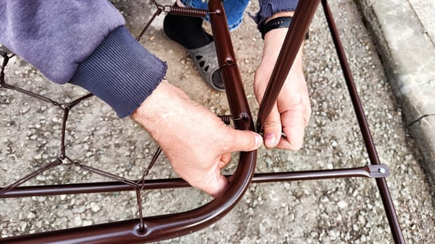 Worker holds metal rods in his hand and staples them