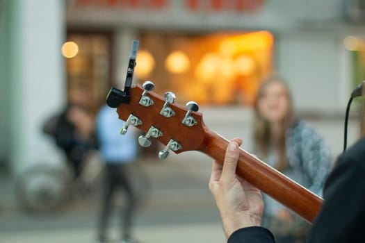 Street musician with guitar. Playing acoustic guitar. Performance on street. Artist performs composition.