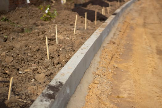 New messes on road. Repair of road. Details of construction works. Concrete blocks are fixed in ground. Background construction sites.a.