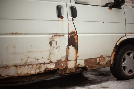 Rusty car bottom. Rust on surface of transport. Old white bus. Transporter of 90s.