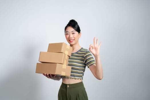 Businesswoman with carry delivery and showing okay sign, white background