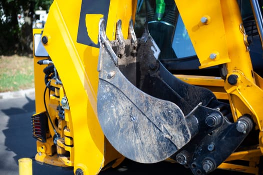 Excavator at a construction site. Construction site. Heavy machinery works. Metal bucket for soil collection.