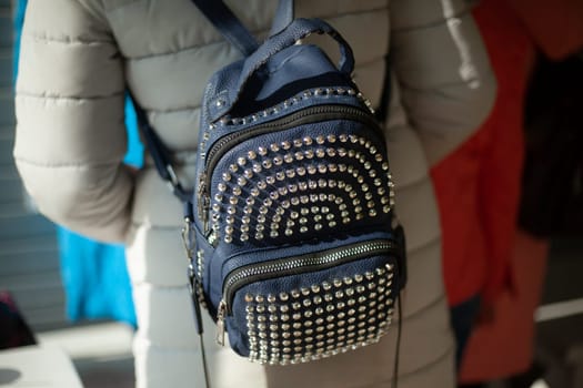 Backpack made of rivets. Pack rivets on bag. Fashionable backpack on girl. Steel details in clothing.