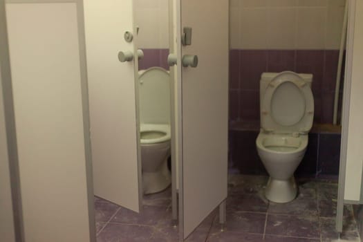 Toilet cabin. Toilet in shopping center. Restroom in office. Dirty room. Bathroom interior details.