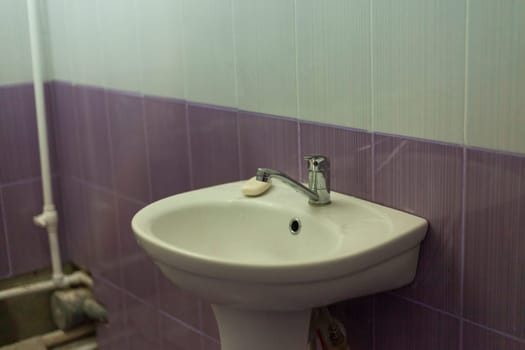 Sink in bathroom. Hand washbasin. Restroom in house. White plumbing in toilet.