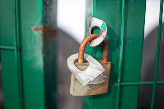 The castle hangs on the gate on the street. Closed door. Private property protection. The door lock is locked.