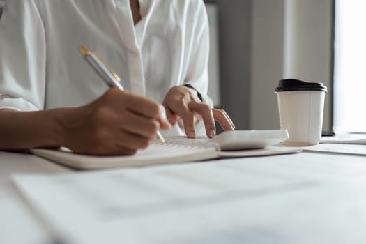 Woman accountant working with computer and calculator for business and financial expense.