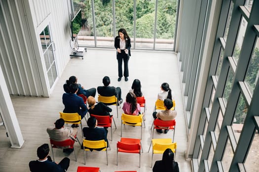 Bird's-eye view of a productive executive meeting. Businesswoman and businessman engage in discussions. Teamwork, planning, and strategy lead to corporate success in a diverse office