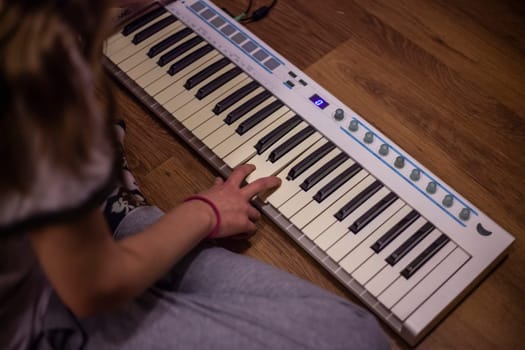 Playing piano. Girls play keys. Synthesizer at home. Hobby music. Fingers press buttons.