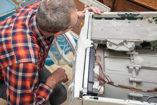 The owner is a jack of all trades who can fix a broken washing machine himself, detect the breakdown and fix it, High quality photo