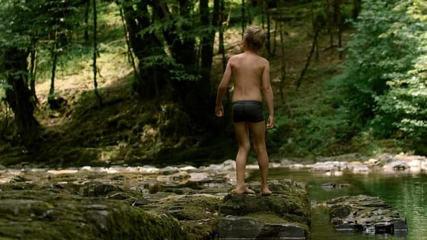 Vacationers and bathing families. Creative.People in swimsuits walking on the lake in the mountains and green thickets of trees are visible. High quality 4k footage