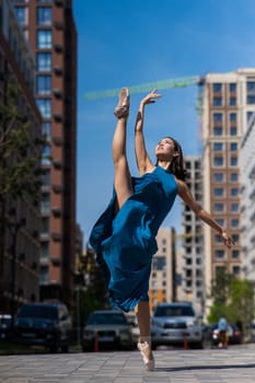 Beautiful Asian ballerina dancing outdoors. Urban landscape