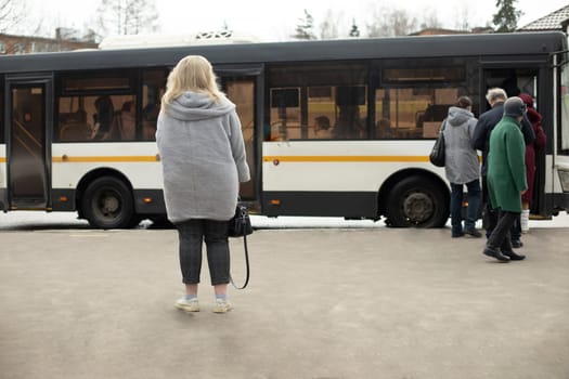 People are waiting for bus. Russians at bus stop. Lot of people in town.