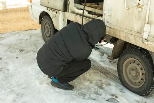 Man drains gasoline from car. Guy steals fuel. Driver pumps diesel fuel.