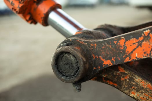 Hydraulic holder. Tractor parts. Heavy machinery up close. Orange equipment. Hard grip.