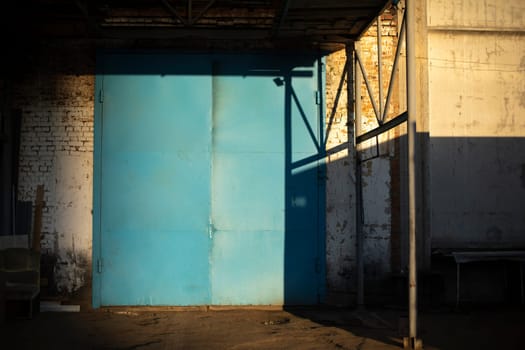 Gate to large garage. Blue gate to warehouse. Industrial zone. Entrance to building.