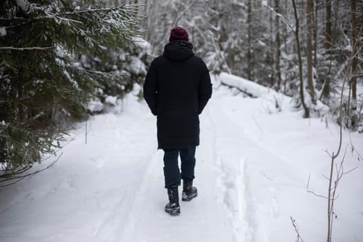 Man in winter on street. Townsman on road. Road is in snow and man.