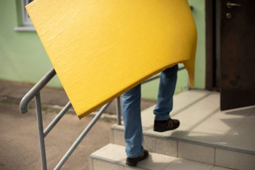 Cleaning of sports equipment. Yellow mat in hand. Loader carries thing. Portability of sports equipment.