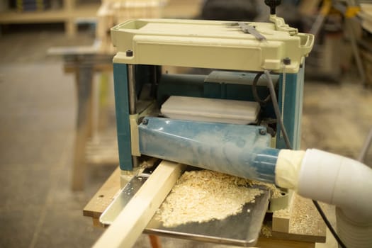 Cutting board in wood workshop. Processing of wood bar. Sawing off layer. Tool in workshop.