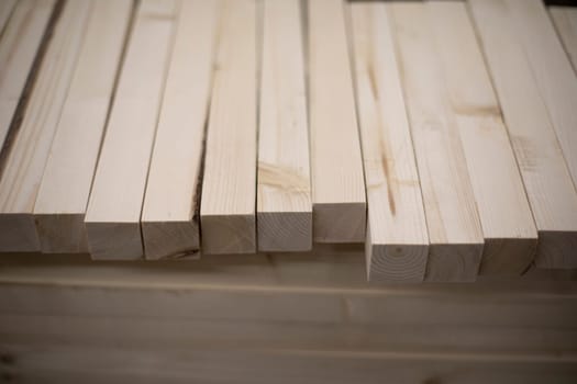 Boards in stock. Wooden blanks. Bars made of wood of light color. Details of steelwork.