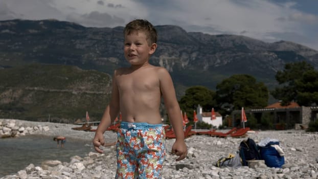 Beach with tourists. Creative. Running children in good weather near the sea and river and mountains overgrown with thickets. High quality 4k footage