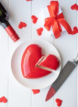 Valentines day. heart shaped glazed valentine cake and flowers on wooden table