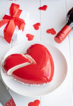 Valentines day. heart shaped glazed valentine cake and flowers on wooden table