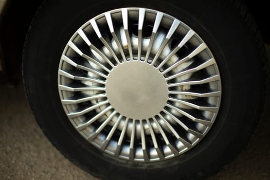 Car wheel. Hubcap on wheel. Vehicle tuning details. Drive wheel. Retro style. Black tire.