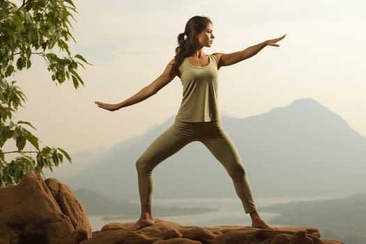 A woman on a mountain background is doing yoga, doing sports and leading a healthy lifestyle. Girl 20 year old stretches to the side.
