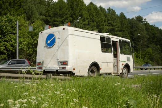 Bus on road with signal lights. Maintenance of road. Transport for road workers.