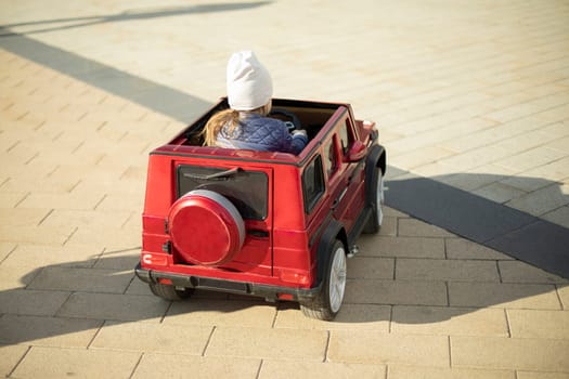 Electric transport for child. Girl in small car. Child rides electric car.