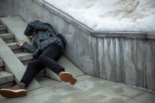 Man fell. Guy is lying on pavement. Falling on stairs. Man stumbled. Loss of balance.