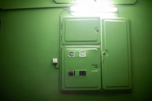 Electrical equipment in entrance of house. Electricity meter on floor. Steel doors for equipment.