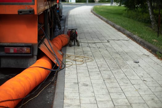 Sewer repair. Orange pipe. Details of works in city. Repair of infrastructure.