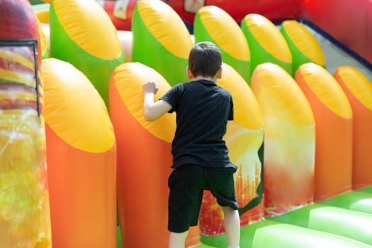 Child on obstacle course. Children's entertainment area. Inflatable design for children.