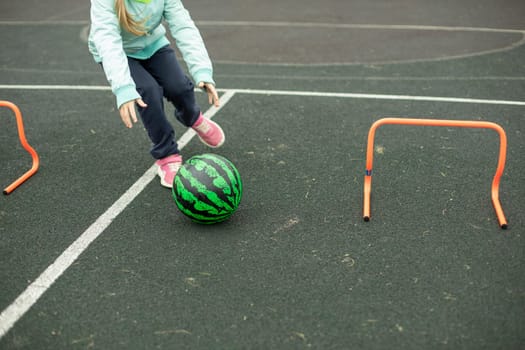 Relay for children. Sports game. Children roll meat around playground. Fun in summer. Competition for agility.