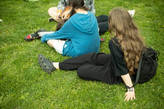 Children in summer relax on green grass. Girls in park. Relax on hot day.