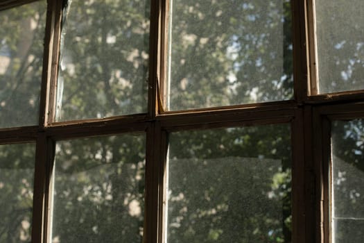 Old window frame. Glass on window. Interior details. Morning light on dusty glass. Old housing.