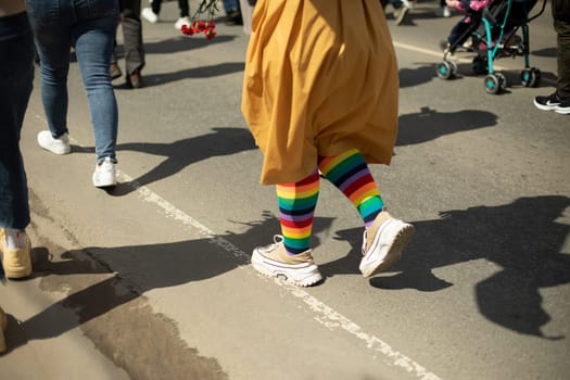 Colored socks on legs. LGBT symbol at procession. Colorful stockings on street. Rainbow in fabric.