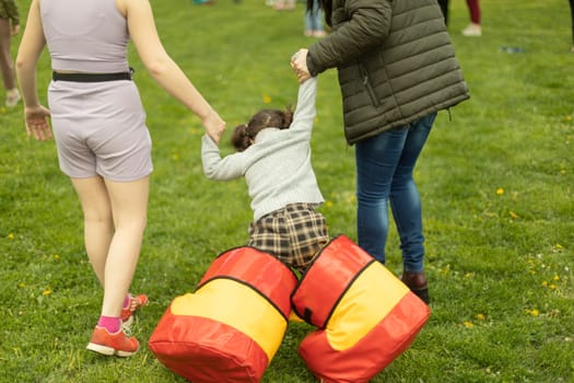 Child plays on green grass. Active lifestyle in summer. Children in park. Attraction for teenagers and toddlers.