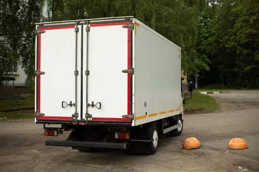 Truck with white body. Truck transport on street. Container for transportation of goods.