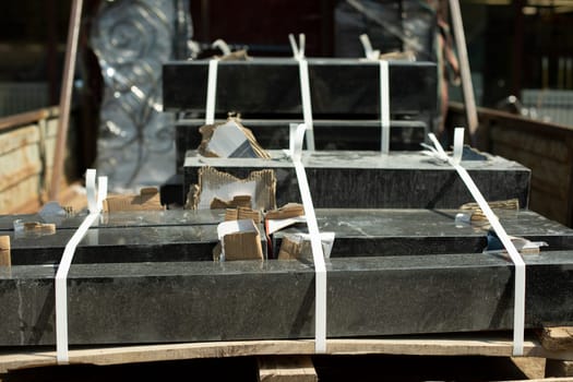 Granite stone in back of truck. Transportation of stone for graves. Details of cargo transportation. Black blocks loaded into truck.