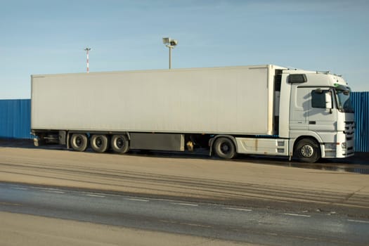 Truck in parking lot. White trailer. Large transport. Truck for transporting goods.