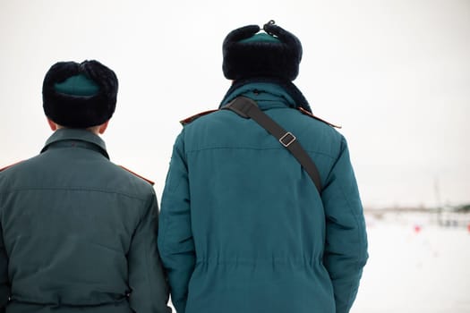 Two rescue workers. Men in uniform. Warm lifeguard uniform in Russia. Two employees guys.