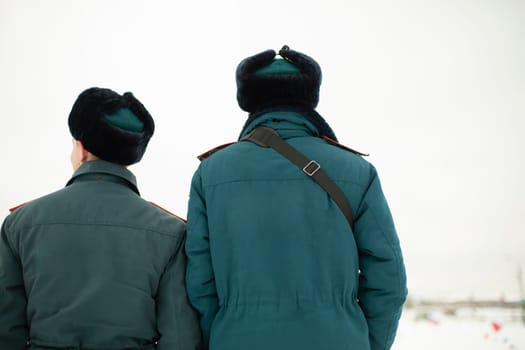 Two rescue workers. Men in uniform. Warm lifeguard uniform in Russia. Two employees guys.