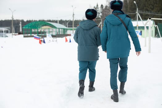 Two guys in uniform. Men come from service in Russia. People in warm clothes in Siberia. Blue shape. Rescue service.