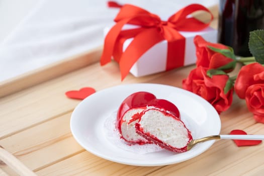 Valentines day. heart shaped glazed valentine cake and flowers in wooden tray